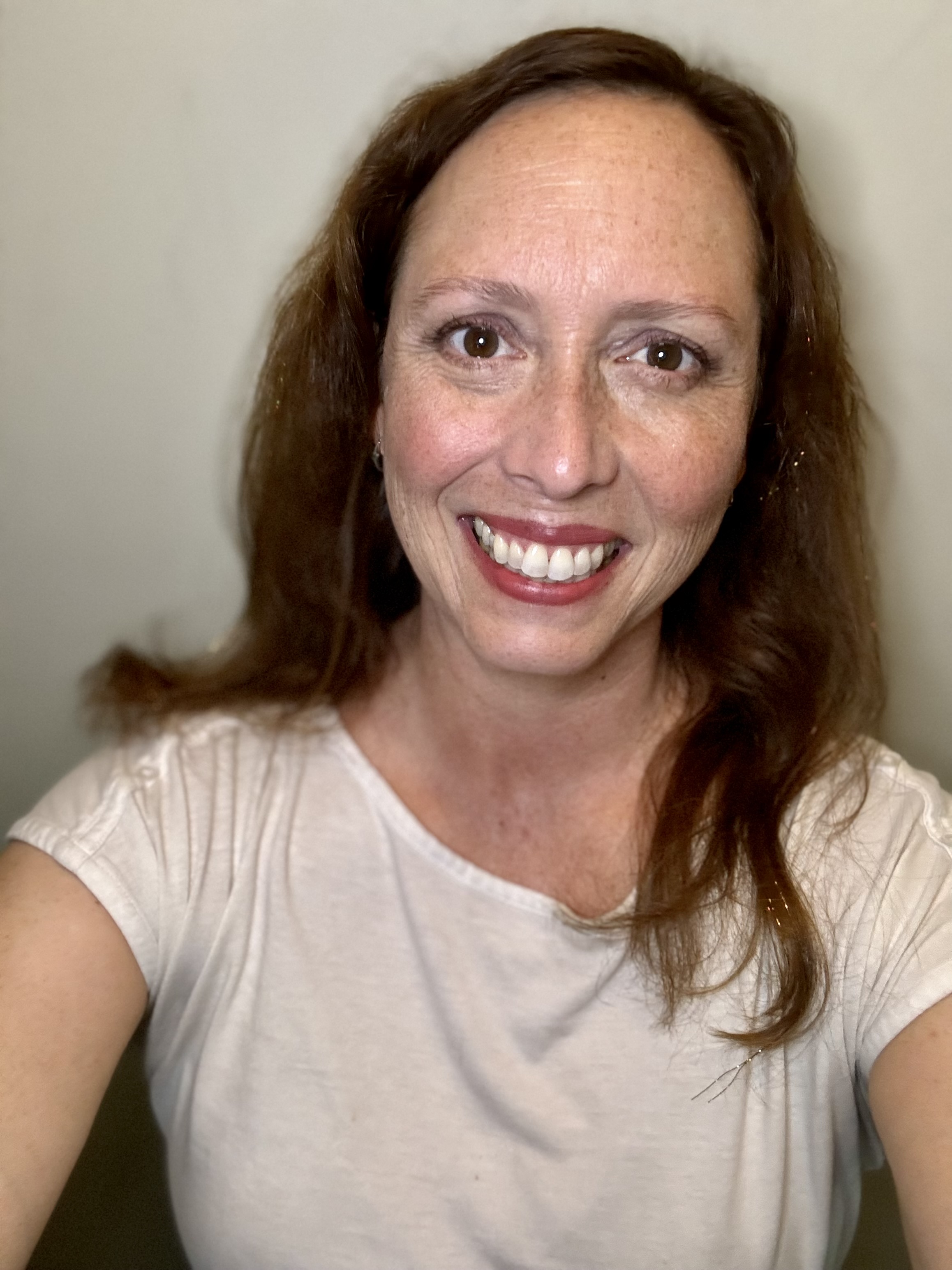 A beige satin eye mask with a delicate floral embroidery lies atop a bed, its appropriately blurred background anchored by...